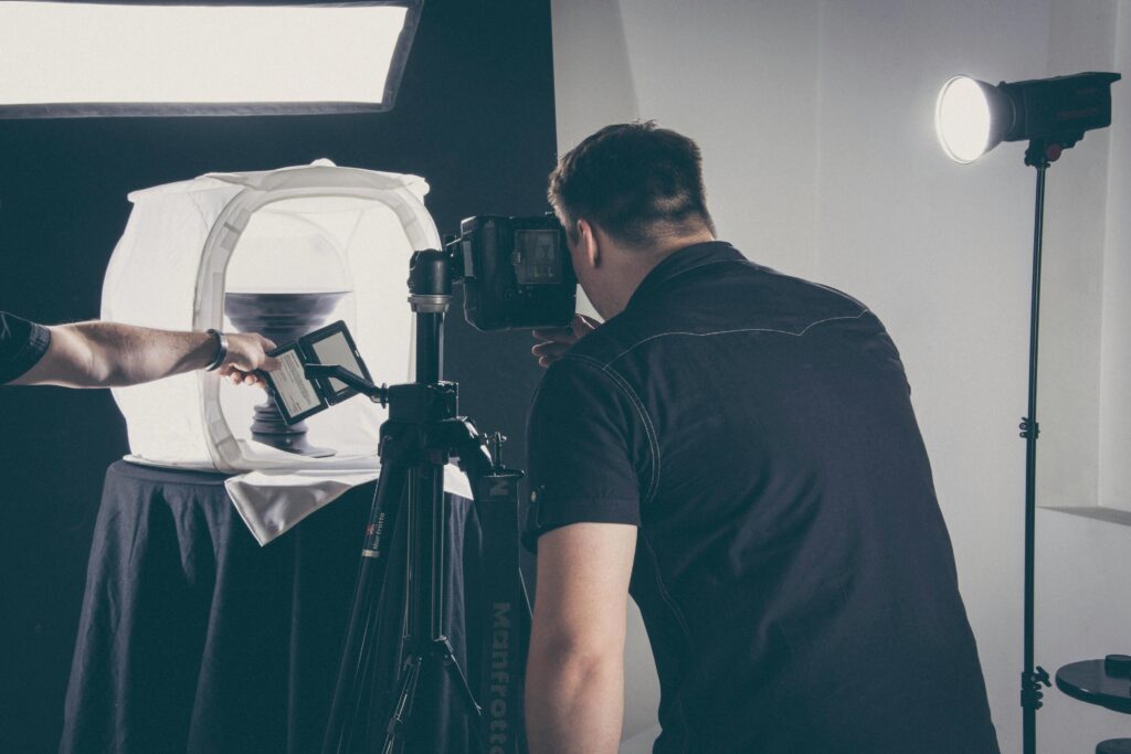 pexels photo 1391786 1391786 Photographer capturing product in a studio setup with lighting gear and camera.